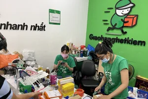 Nhân viên Trung tâm Giao nhận hàng tiết kiệm (trên đường Nguyễn Văn Cừ, quận 1, TPHCM) phân loại hàng để giao cho shipper. Ảnh: HOÀNG HÙNG