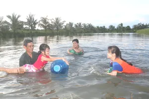 Các em học sinh tập bơi trong vuông tôm, để trang bị kỹ năng phòng chống đuối nước tại phường 9, TP Cà Mau, tỉnh Cà Mau. Ảnh: TẤN THÁI