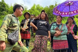 Trưởng bản Mùa A Thi (bìa trái) trao đổi với bà con thoát nạn lũ quét