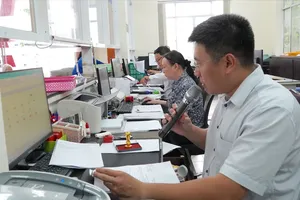 Cán bộ không chuyên trách phường Tân Thuận tiếp nhận thủ tục hành chính của người dân tại Trung tâm Phục vụ hành chính công phường. Ảnh: PHƯƠNG UYÊN