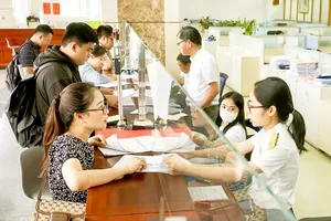 Tiếp nhận và giải quyết hồ sơ thuế tại trụ sở Thuế TPHCM. Ảnh: HOÀNG HÙNG