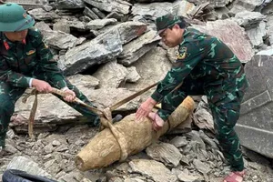 Lực lượng chức năng tiến hành di chuyển quả bom đến khu vực xử lý an toàn