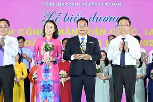 Chủ tịch Tổng LĐLĐ Việt Nam Nguyễn Anh Tuấn và Phó Bí thư Thành ủy TPHCM Đặng Minh Thông chúc mừng các gia đình được biểu dương. Ảnh: VIỆT DŨNG