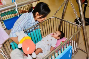 Chị Trần Thị Kim Chi, nhân viên Phòng công tác xã hội và phát triển cộng đồng của Trung tâm Bảo trợ và Công tác xã hội bên các con được nuôi dưỡng tại trung tâm