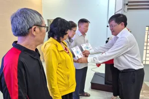 Người dân phường Trung Mỹ Tây, TPHCM nhận thẻ BHYT miễn phí theo Nghị quyết 56/2025/NQ-HĐND của HĐND TPHCM. ẢNH: MAI CHI