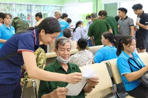 Lực lượng tình nguyện của phường Chánh Hiệp hỗ trợ người lớn tuổi thuộc diện gia đình chính sách đi khám sức khỏe. Ảnh: THẢO NGUYỄN