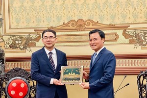 胡志明市人委会副主席裴春强向广州市副市长赖志宏赠送纪念品。