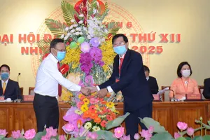 Đồng chí Nguyễn Hữu Hiệp (trái) tặng hoa chúc mừng đại hội
