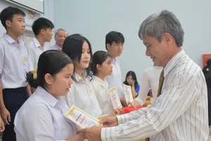 Ông Hồ Cảnh Hạnh, Phó Chủ tịch Hội Khuyến học TPHCM trao học bổng cho các em học sinh.