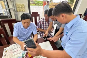 Chi cục Thủy lợi và biến đổi khí hậu TP Huế hướng dẫn người dân sử dụng thông tin cảnh báo thiên tai qua điện thoại thông minh và tờ rơi. Ảnh minh hoạ: VĂN THẮNG