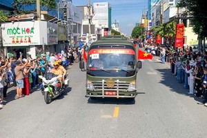 车队途经各条道路，沿途众多民众怀着崇敬与感恩之情，向烈士致以深切哀悼。图片：孟胜