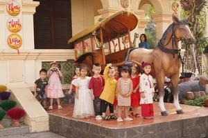 Trẻ em xúng xính váy áo chụp ảnh bên xe thổ mộ