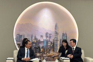 胡志明市人委会主席阮文得（左）与深圳市政务服务数据管理局副局长张军举行工作会谈。图：陈雄－阮国