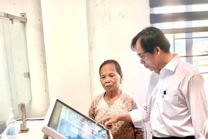 会安市（广南省）社保机关领导指引民众如何通过个人VssID账户登入数字账户。图：文福