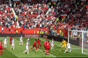 Canada suýt có bàn gỡ hòa, Laryea nỗ lực sút bóng, Vasilj đỡ bóng, hậu vệ Kolasinac phá bóng dội trúng xà ngang bật ngược ra