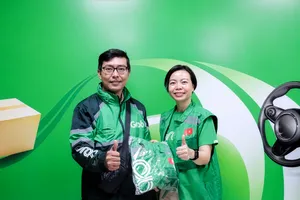 Bà Lý Thụy Bích Huyền, Giám đốc Vận hành, Grab Việt Nam, trao đồng phục tặng các bác tài Grab