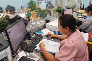 Công chức phường An Phú Đông (TPHCM) tiếp nhận, giải quyết hồ sơ thủ tục hành chính cho người dân. ẢNH: NGÔ BÌNH