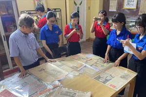 Cựu chiến binh Nguyễn Tiến Bình giới thiệu với các bạn trẻ về tư liệu, sách, báo được lưu giữ tại Không gian văn hóa Hồ Chí Minh. ẢNH: THẢO NGUYỄN