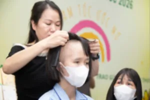 Một bệnh nhân ung thư vui mừng đón nhận mái tóc giả từ chương trình “Trạm tóc ước mơ”. Ảnh: THANH HẰNG