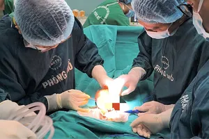Bác sĩ phẫu thuật cắt vòng kim loại giải phóng vùng bị chèn ép. Ảnh: ĐẶNG THANH