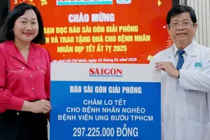 Bà Bùi Thị Hồng Sương - Phó Tổng Biên tập Báo Sài Gòn Giải Phóng trao bảng tượng trưng cho TS.BS. Diệp Bảo Tuấn - Giám đốc Bệnh viện Ung Bướu TP. Hồ Chí Minh. Ảnh : VIỆT NGA