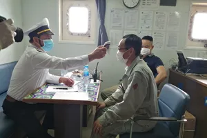 Đo thân nhiệt thuyền viên trước khi đưa lên bờ cách ly