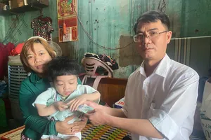 Nhà báo Nguyễn Hùng, Trưởng đại diện Báo SGGP tại miền Trung trao 10 triệu đồng hỗ trợ cháu Nguyễn Võ Chí Tài