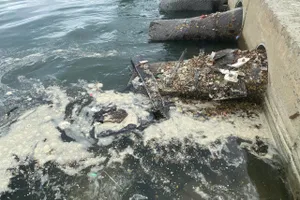 Nước thải bẩn kèm theo rác chảy thẳng ra biển gây ô nhiễm. Ảnh: PHẠM NGA