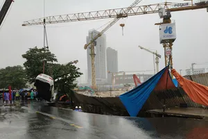 Lực lượng chức năng điều động xe cẩu cứu hộ ô tô bị rơi xuống hố