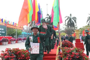 Công dân cười tươi vẫy tay chào người thân sau khi đi qua cầu vinh quang. Ảnh: NGUYỄN CƯỜNG