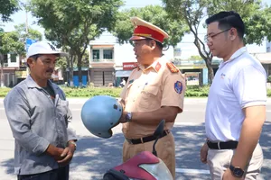 Thượng tá Phạm Hồng Hải, Phó Trưởng phòng CSGT tuyên truyền, tặng mũ bảo hiểm đạt chuẩn cho người dân