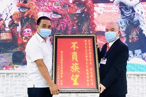 　　繼交護國觀音廟理事會交際謝振廣（左）向 羅志榮理事長贈送禮物祝賀。