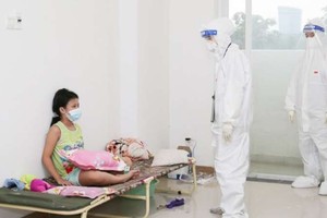 醫護人員在問候確診少兒的病情。