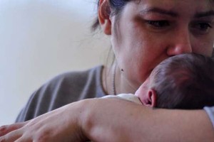 一位母親抱著她剛出生的嬰兒。