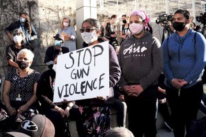 去年，人們手舉“停止槍枝暴力”的標語在參加槍擊案受害者悼念儀式。