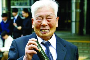 舛谷拿著畢業證，面露笑容。