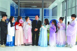 　　文獻大學外語系副主任賴開榮(中)與參加表演的大學生合照留念。