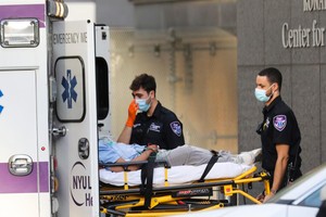 醫護人員在美國紐約一家醫院外轉運病人。（新華社記者王迎攝）