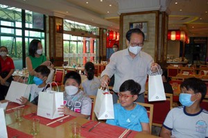 越南時代廣場投資股份 公司總經理張豐裕先生和 女兒向清寒學生贈送禮物。