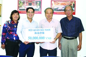 海南會館常值副理事長孫盛強 (右二)把贊助贈報經費移交給本報 編委文忠孝(左二)。