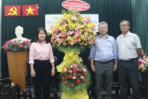 本報編委黎曰孟雄接受第五郡代表團 贈送的鮮花。