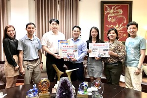 本報編委文忠孝(左四)向簡智明董事長 (左三)贈送日報和春刊。