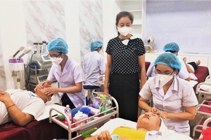 阮必成中專學校教師指導學員實習皮膚護理。