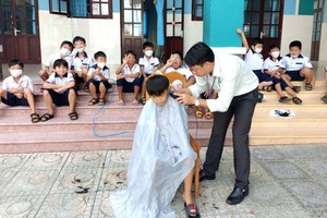 黎友平校長免費給學生修剪頭髮。