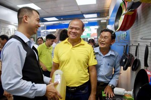 華人青年企業家江勇孝（左一）向消費者推銷產品。