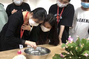 大學生專注玩“投針驗巧”遊戲。