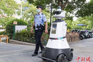 民警與智能警用機器人在街區巡邏。圖源：中新網