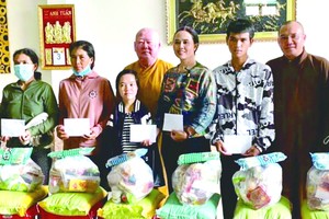 蓮華寺住持釋惟鎮大師(中)向少數民族同胞贈送中秋禮物。