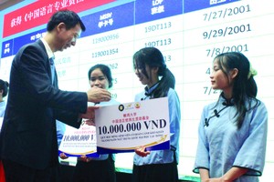 中國駐本市副總領事郝志剛向雒鴻大學好學勤讀的大學生頒發助學金。