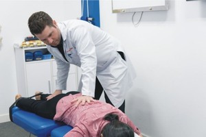 Luke Hamman醫生正在為病人檢查脊柱。